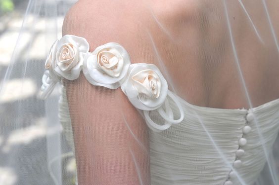 abito da sposa con scollatura omerale manica arricchita da roselline